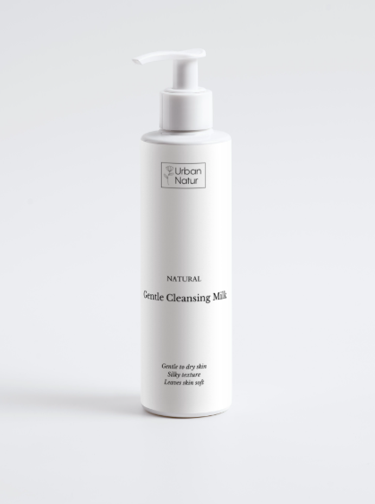 Leche limpiadora natural Urban Natur en envase elegante sobre fondo minimalista. Fórmula hidratante con ingredientes libres de tóxicos, ideal para limpiar y nutrir la piel sensible y madura. Cosmética natural de alta calidad para una piel radiante y saludable.